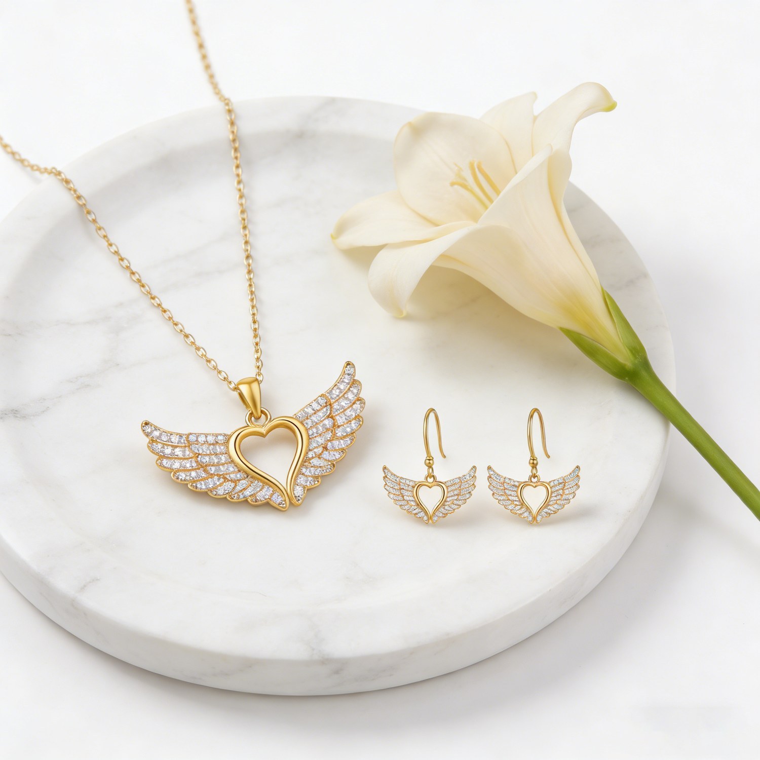 Jewelry set styled on marble surface with flower accent