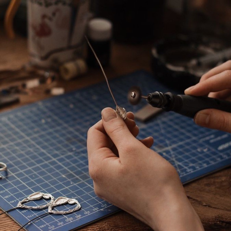 Craftsman hands polishing finished gold plated jewelry during QC