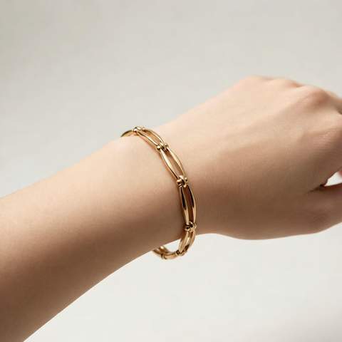 Primer plano de una pulsera chapada en oro de 18 quilates en una muñeca