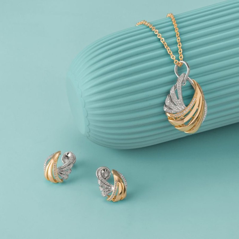 Gold and silver necklace pendant with matching earrings — a complete coordinated jewelry set showing matching design