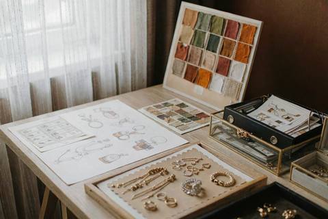 Jewelry design studio desk with autumn seasonal design sketches and sample trays