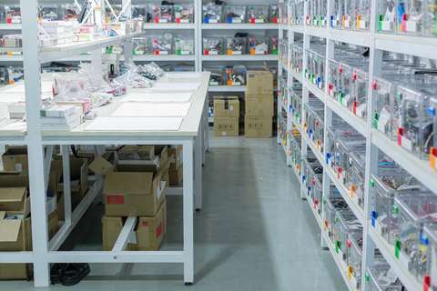 Organized jewelry wholesale warehouse shelving and packing bench with OPP bags