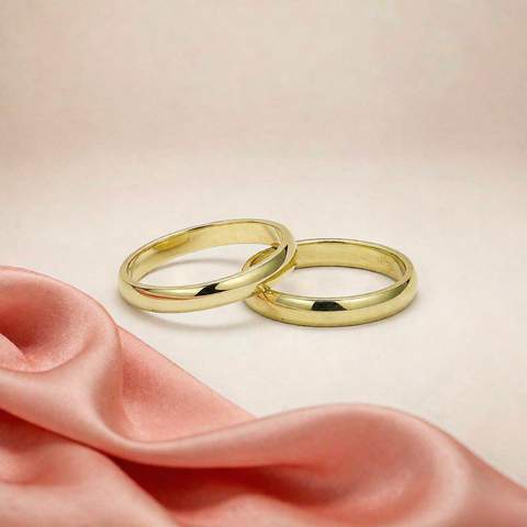 Solid gold ring placed beside a gold plated brass ring for comparison