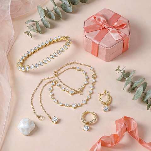 Flat lay of gold plated cubic zirconia jewelry gift sets with a coral gift box