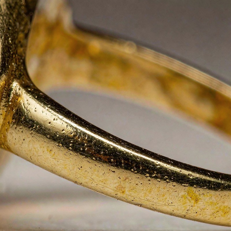 Macro close-up of an 18K gold plated ring shank showing the polished gold layer meeting the brass base
