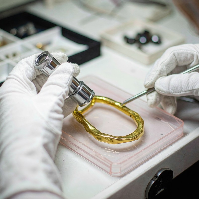 Inspector de control de calidad verificando joyería chapada en oro 18K