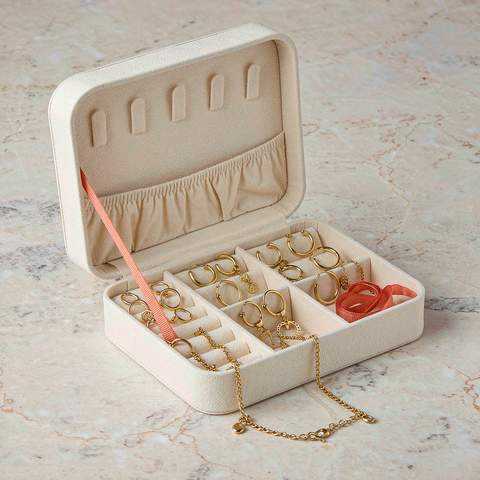 Gold plated earrings and a chain bracelet stored in a lined jewelry box