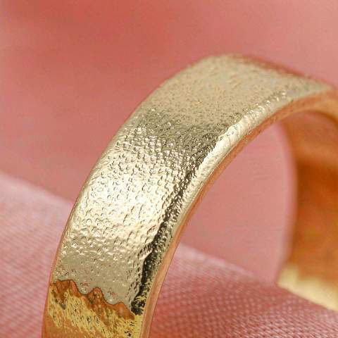 Macro close-up of a gold plated ring band showing the thin gold layer over its brass base