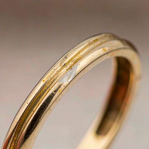 Close-up of worn gold plated ring showing base metal where plating thinned