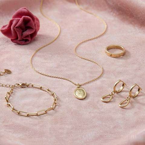 Quality gold plated jewelry pieces on blush pink surface