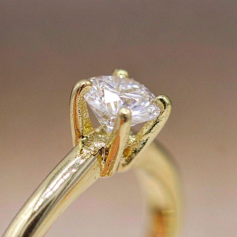 Close-up of 18K gold plated brass ring surface with clear AAA cubic zirconia stone