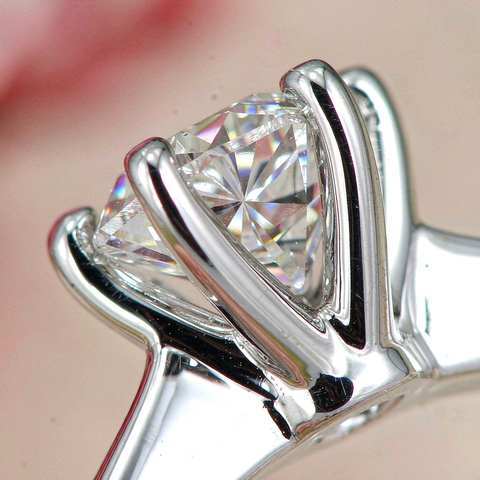 Macro view of metal prongs gripping a faceted cubic zirconia stone
