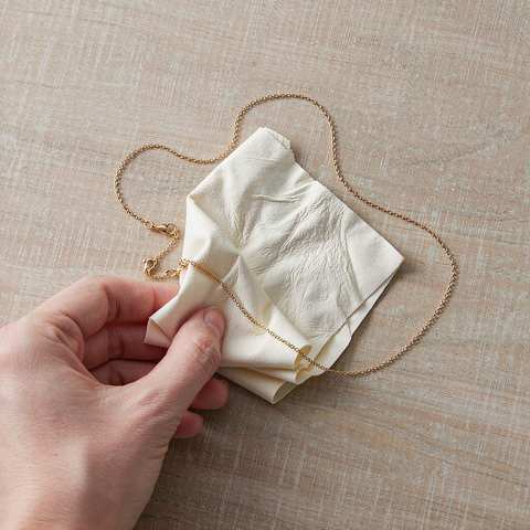 Polishing a gold plated necklace with a soft cloth