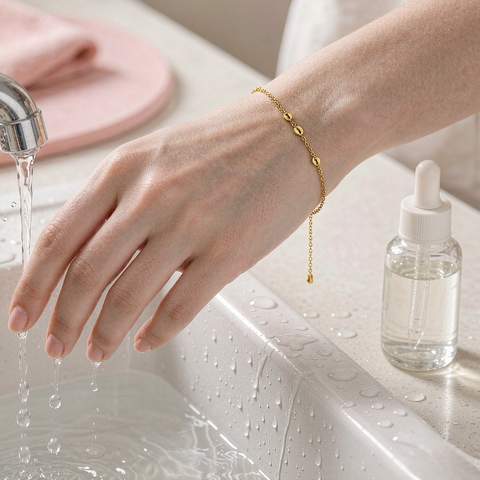 Hand wearing a gold plated bracelet being kept away from running water and cosmetics
