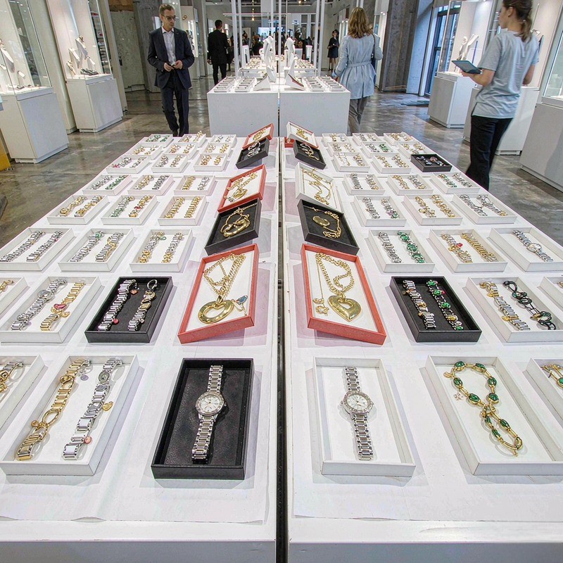 Wholesale showroom with trays of gold-tone fashion jewelry sorted by type for buyer assortment planning