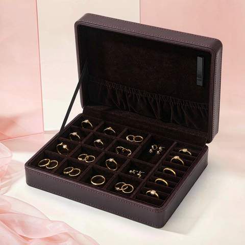 Open jewelry storage box with gold plated rings and earrings placed in separate lined slots