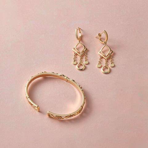 18K gold plated earrings and bracelet flatlay on a blush pink background