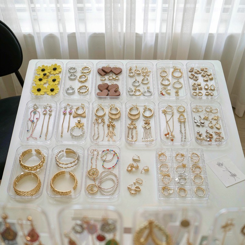 Bright jewelry showroom with trays of gold-tone fashion jewelry sorted by type for wholesale buyer assortment planning
