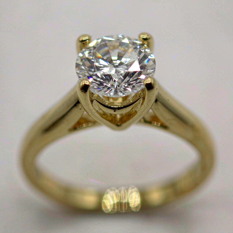 Macro close-up of an 18K gold plated brass ring with a clear AAA cubic zirconia center stone in a four-prong setting