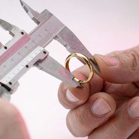 Calipers measuring a gold plated ring during quality inspection