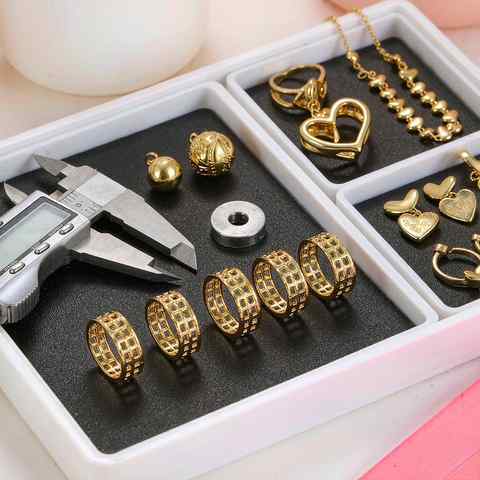 Quality control tray with gold plated jewelry, caliper and measuring gauge