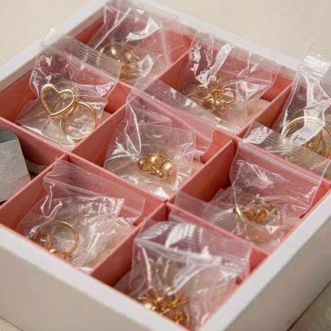 Jewelry organizer with separate compartments holding gold plated pieces in clear bags