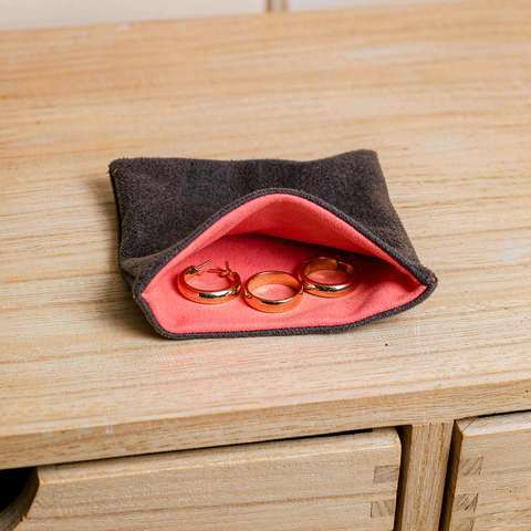 Gold plated earrings and ring resting in a soft pouch inside a dry drawer