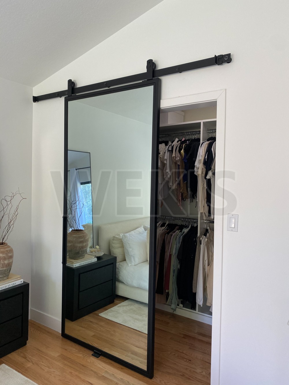 Mirror barn door installed on a bedroom wardrobe opening