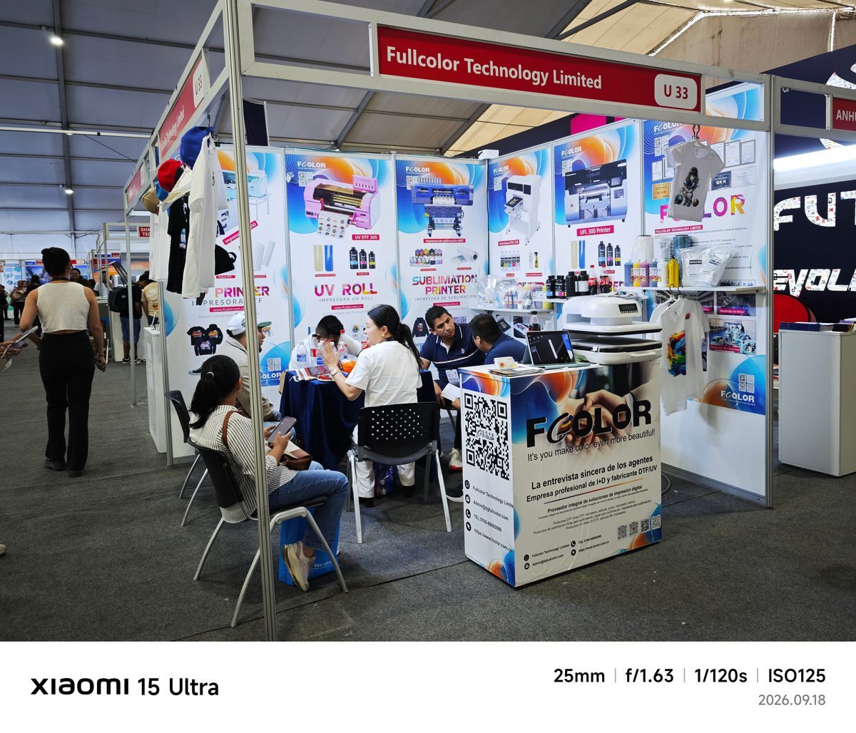 FCOLOR booth U33 with visitors discussing DTF and UV printing