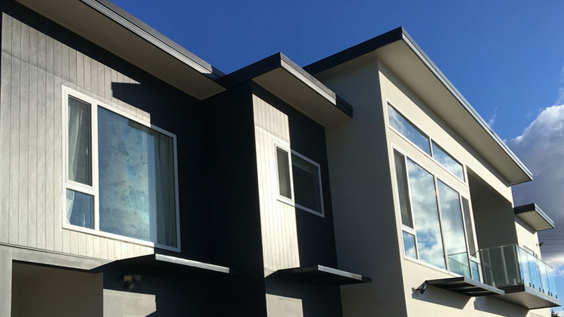 White multi-chamber window frames with sealed glazing units on a coastal new build