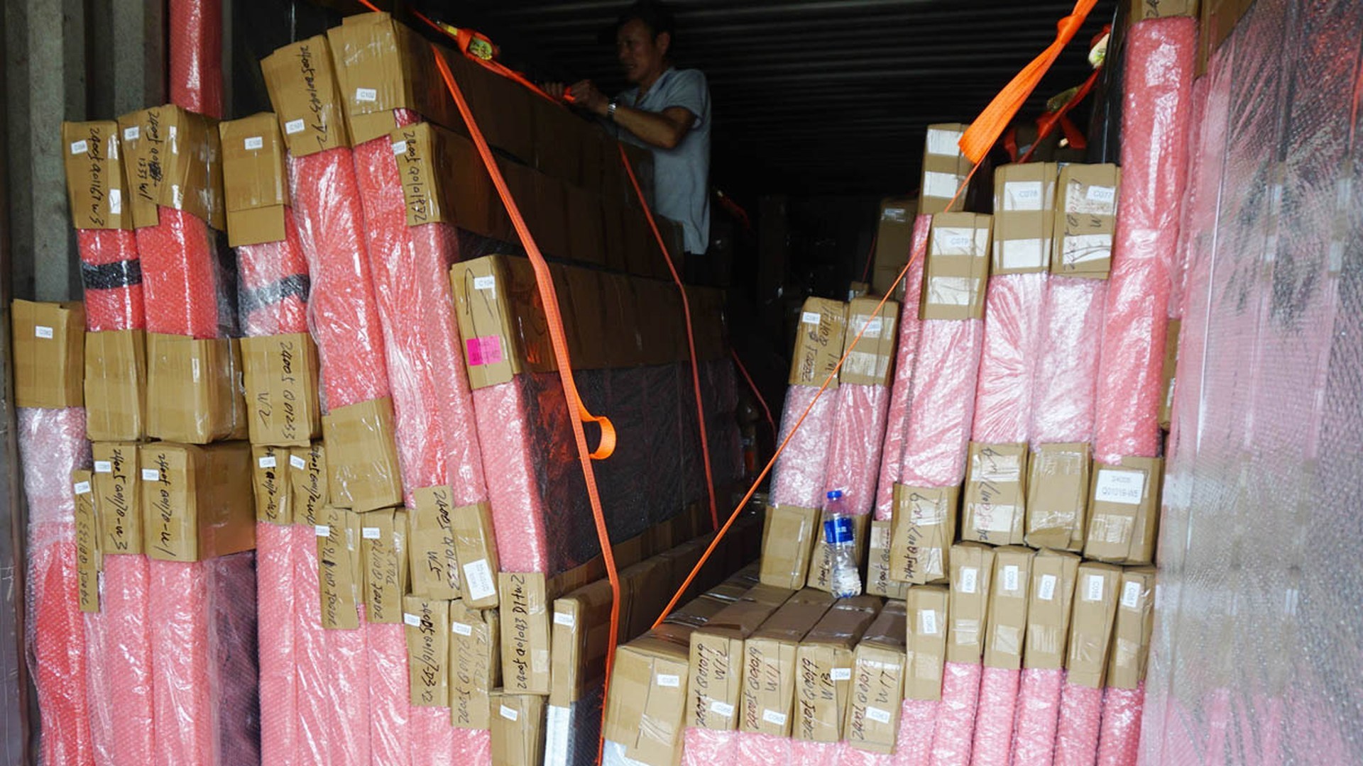 Export loading at the factory: every unit strapped, filmed and labelled before the container doors close