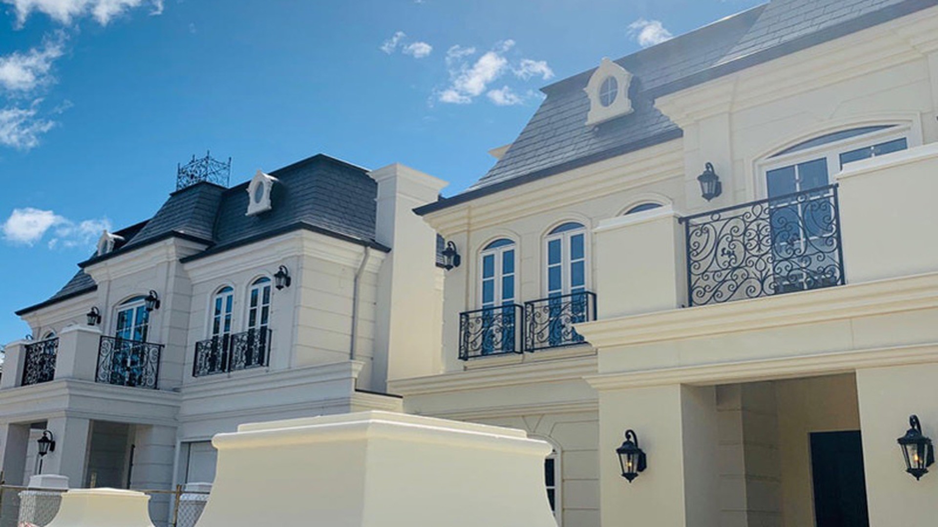 A completed multi-unit residential block with matched windows and doors across every elevation.