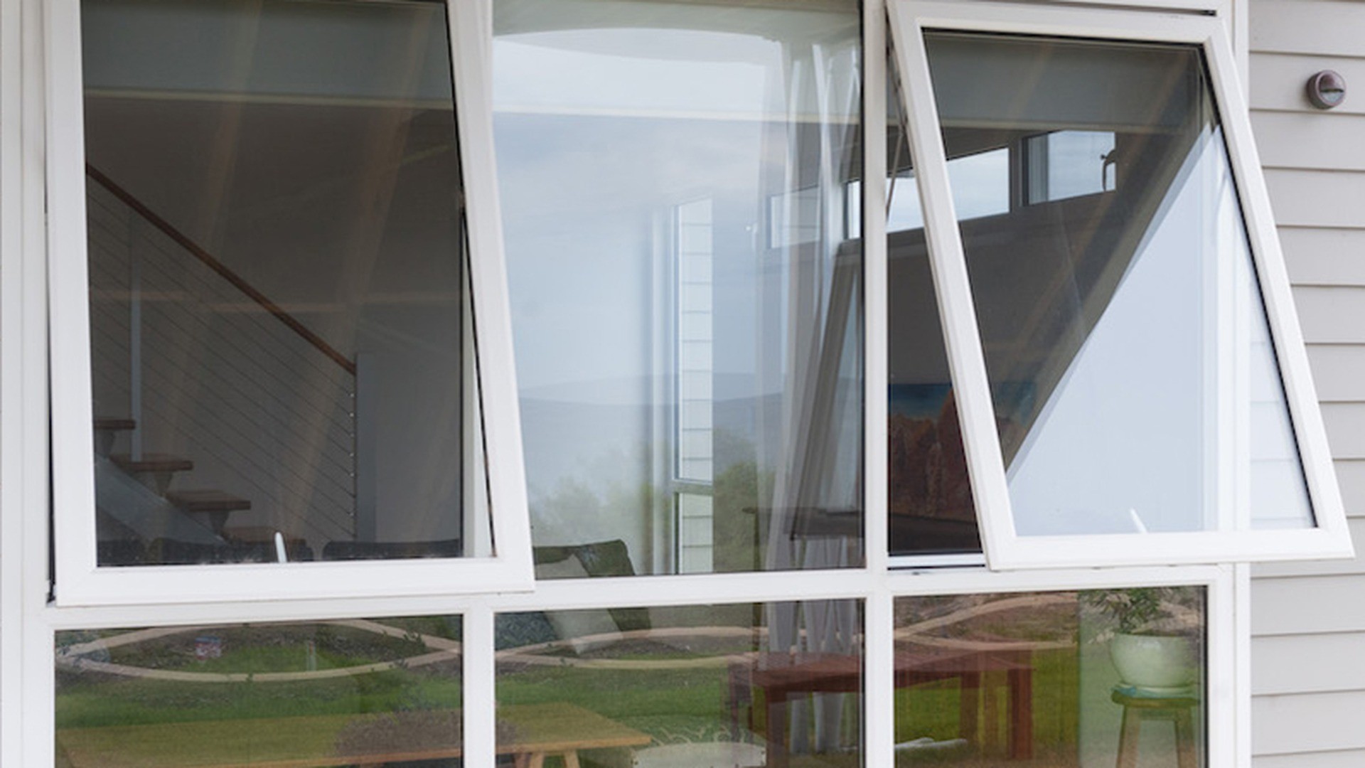 Installed uPVC windows in a residential project, shown with the sashes open for ventilation and cleaning.
