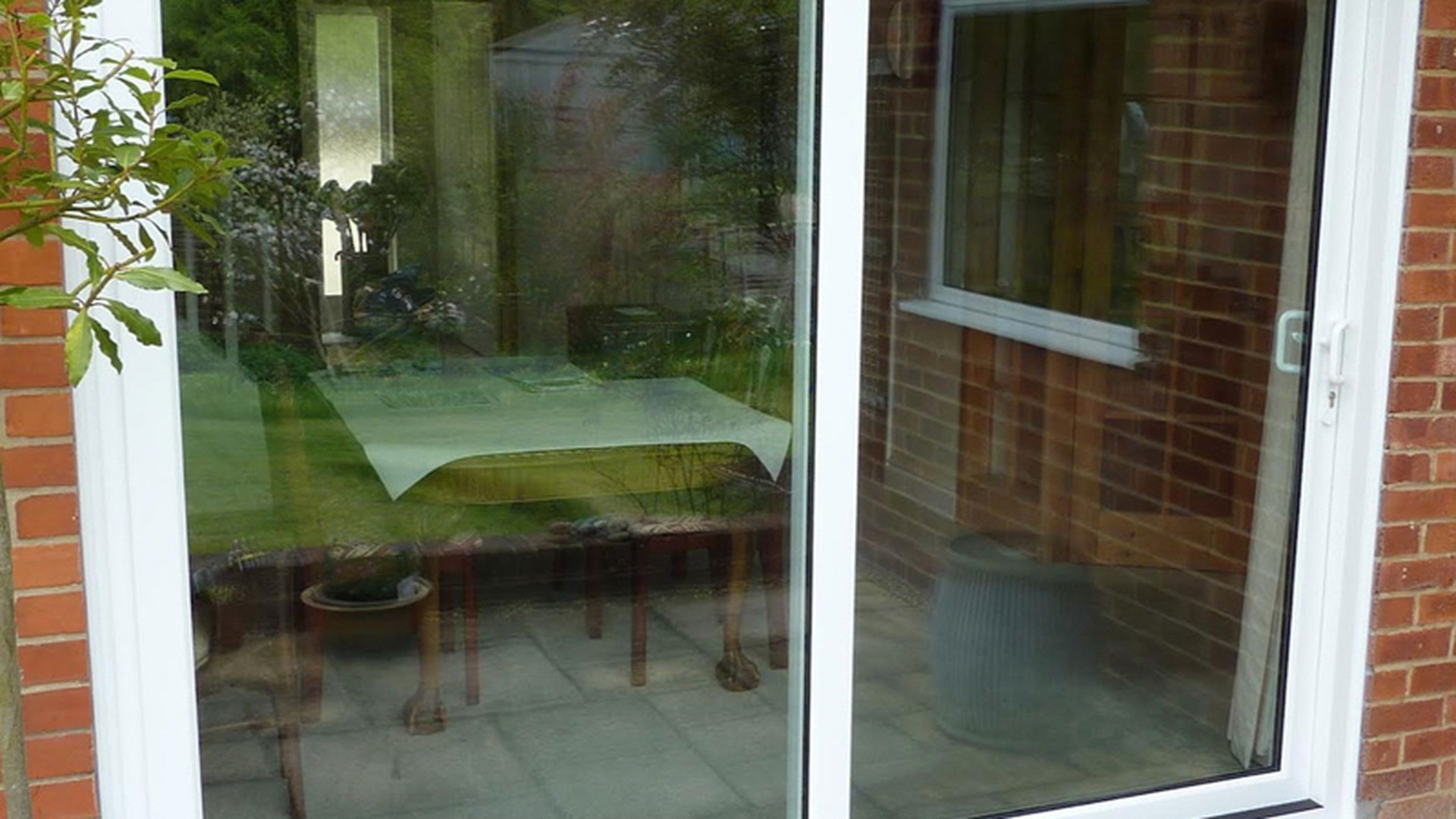 A white sliding patio door and matching window in a finished residential elevation.