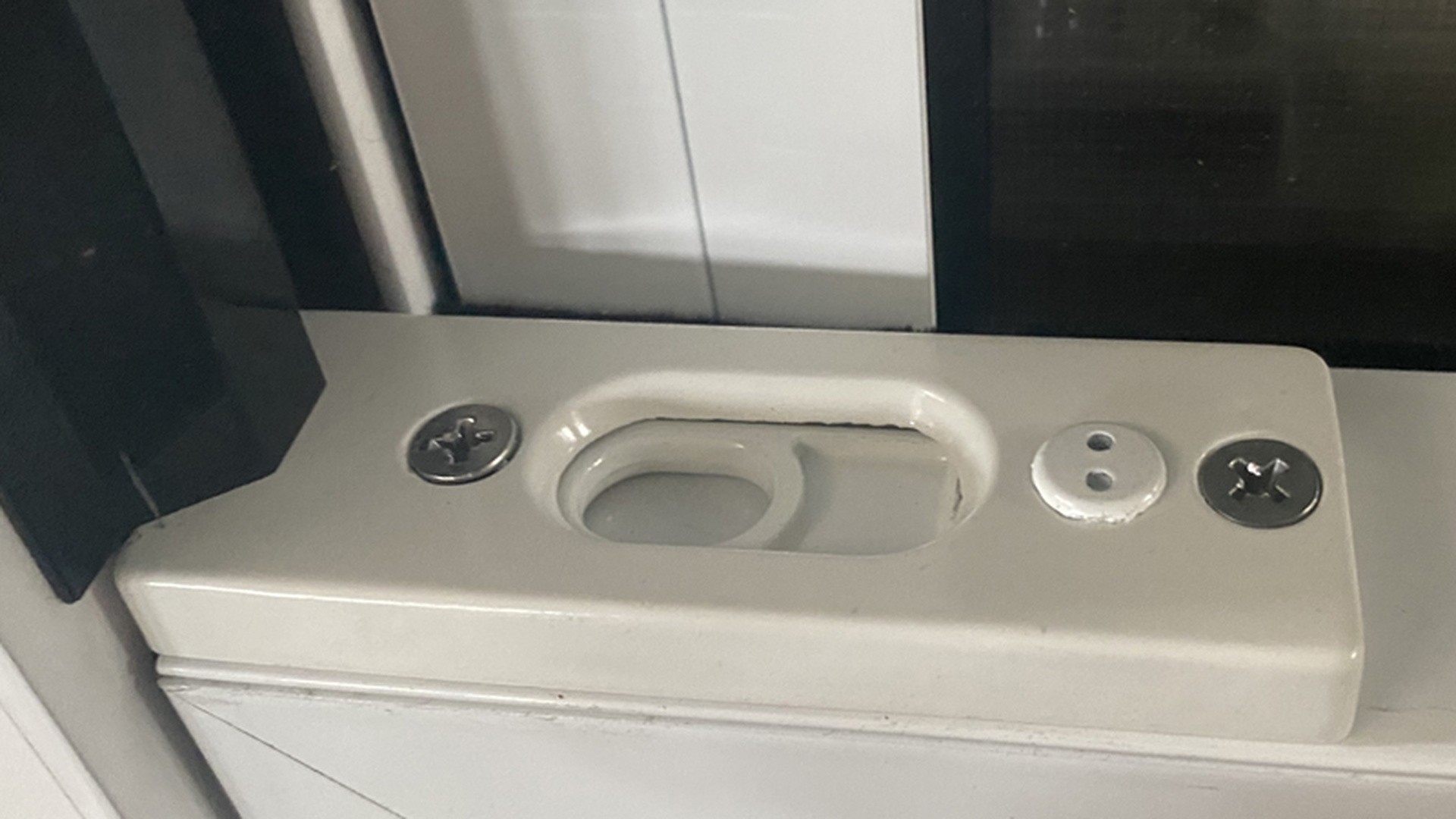 Locking and vent hardware on a finished white window frame, shown at close range.