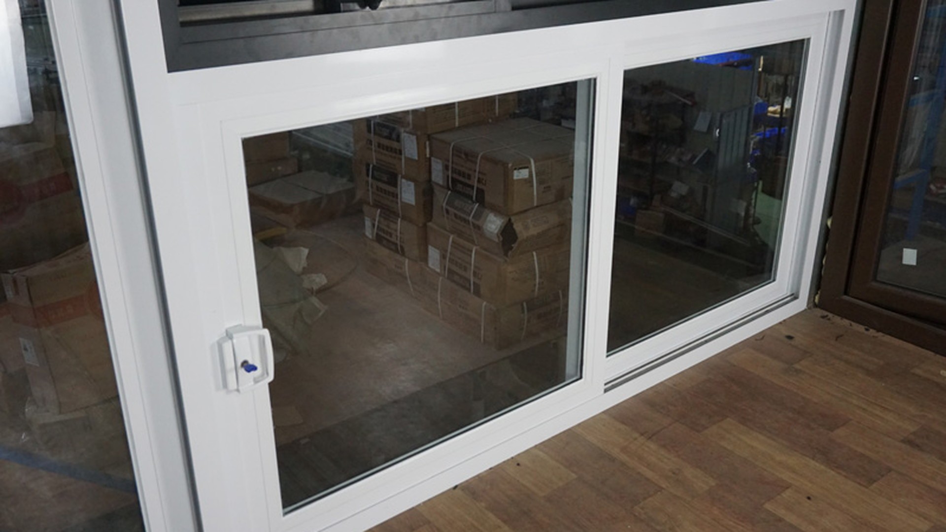 A sealed glazing unit set into its white uPVC frame with the sash and handle fitted: glass, gasket and profile arrive as one unit.
