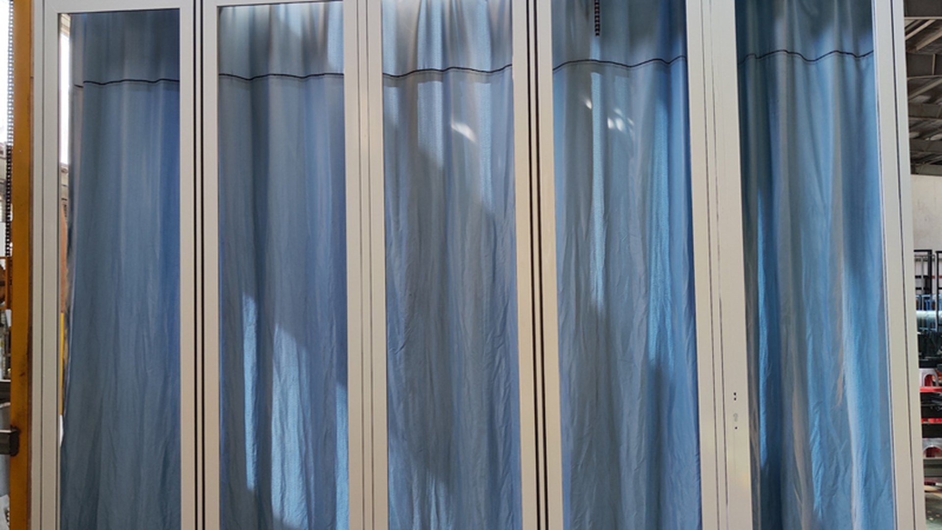 A completed multi-panel folding set standing in the workshop with frame protection still in place, operated and checked before packing.