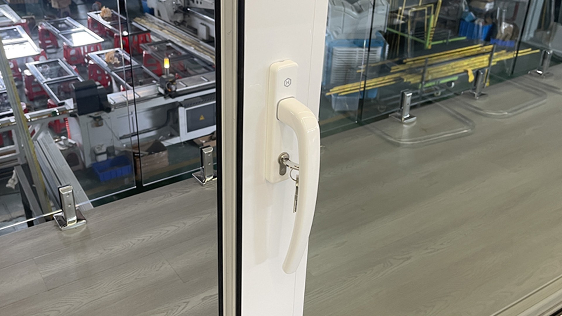 The handle and key cylinder of a lift and slide door at close range: the point where the lift-and-set-down movement is operated and where the sash is pulled across its track.