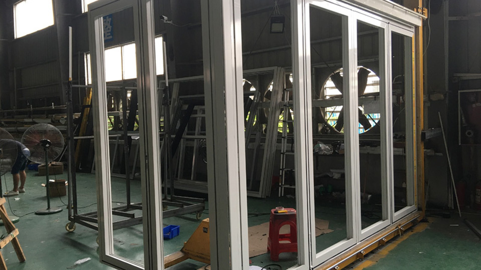 A large glazed unit assembled and standing in the factory: the point where the frame geometry, the reinforcement and the threshold detail have to be right before the door leaves the line.