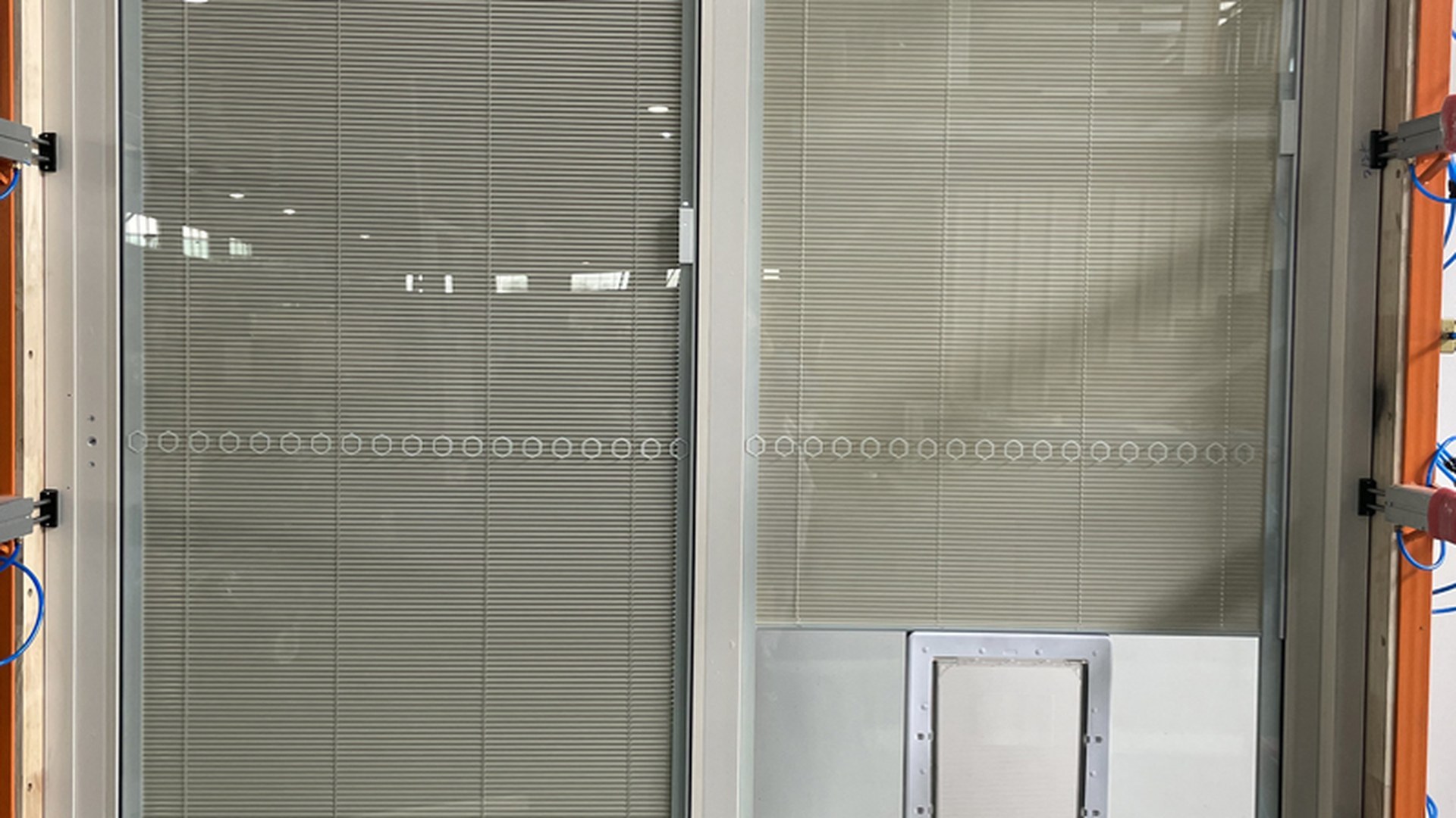 Two sashes with integral blinds at the packing stage: the overlap where one sash slides behind the other is where water and air have to be stopped, and where the blind stack has to fit.