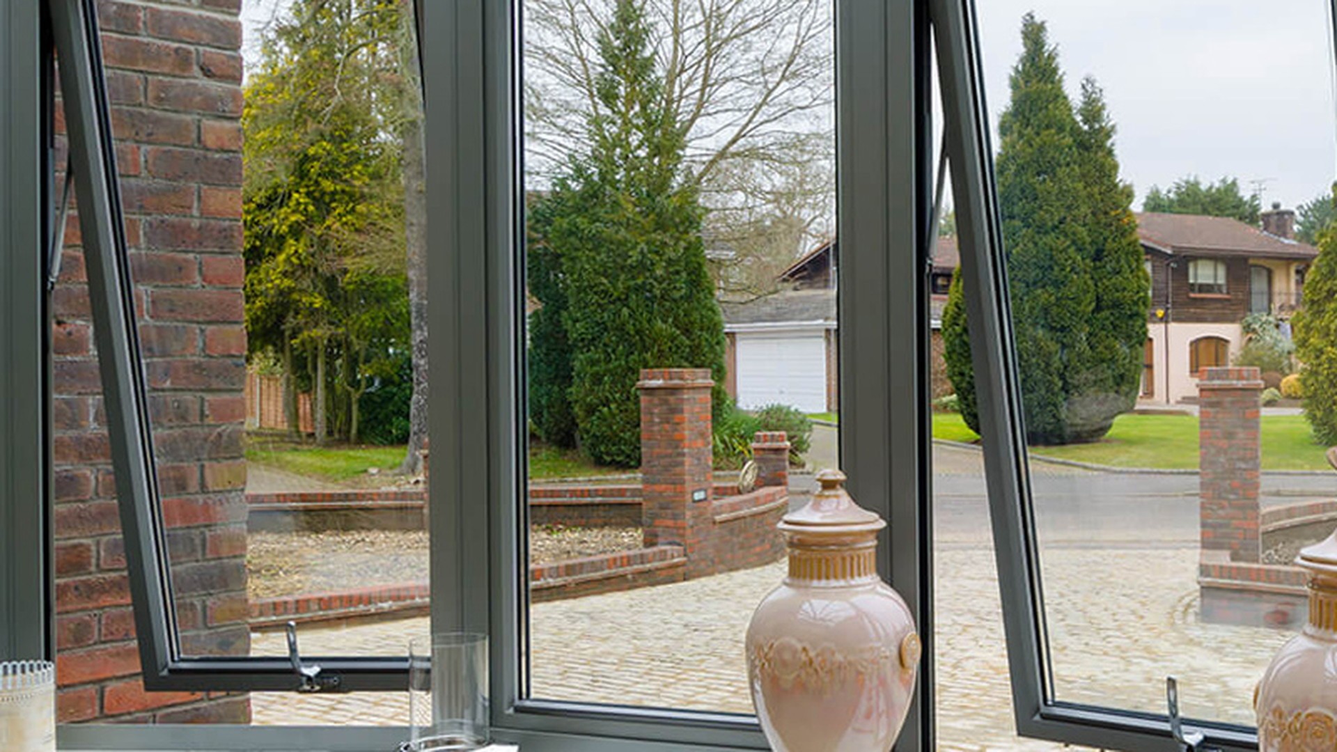 From inside the same kind of bay: the sill steps around the angle, the flanking panels are top-hung and open over the seat, and the returns are where the frame stops being a rectangle.