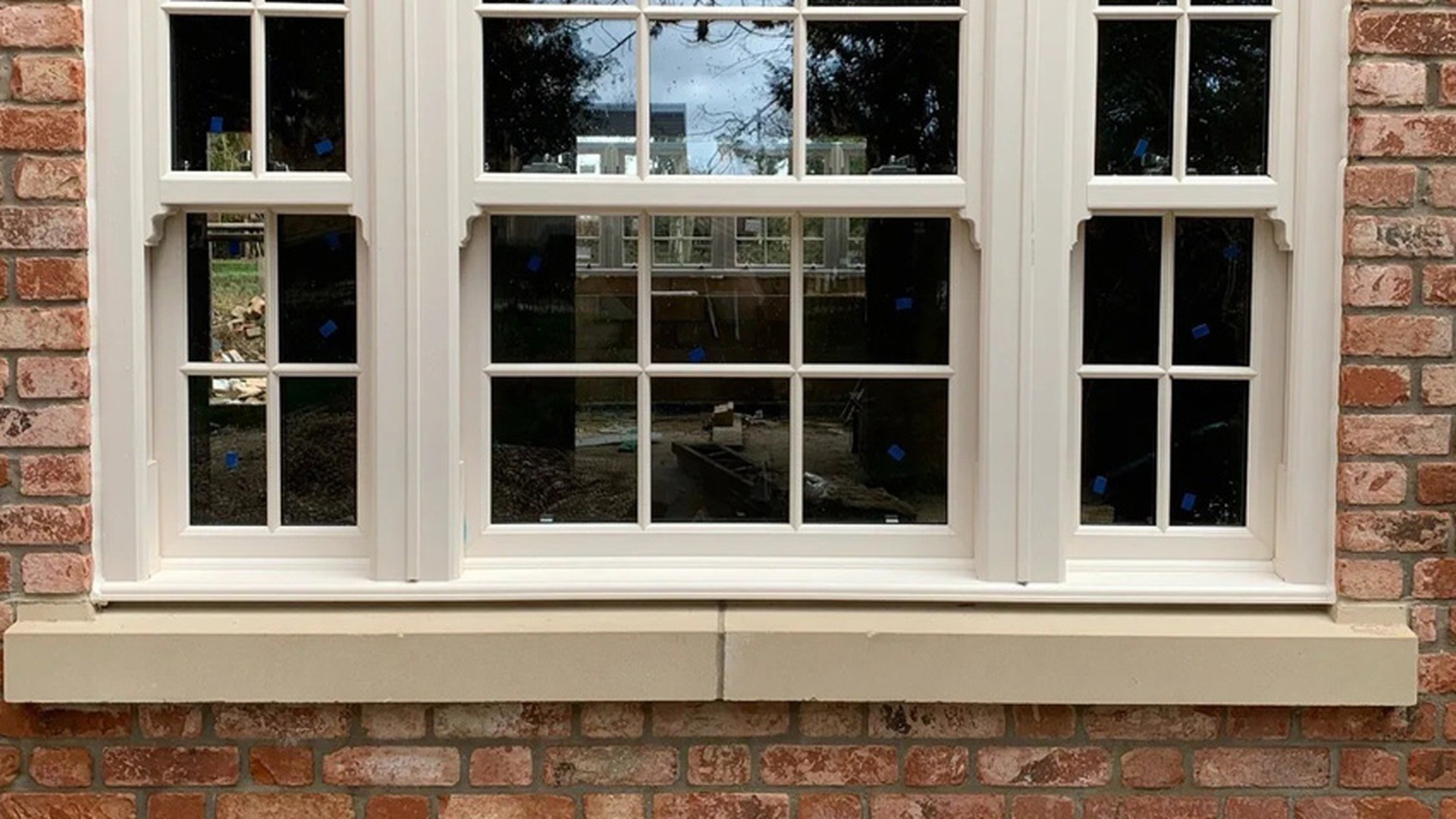 At close range: upper and lower sashes of equal height with the meeting rail across the middle of each light, the sash horn below it, and the external sill that carries water clear of the wall.