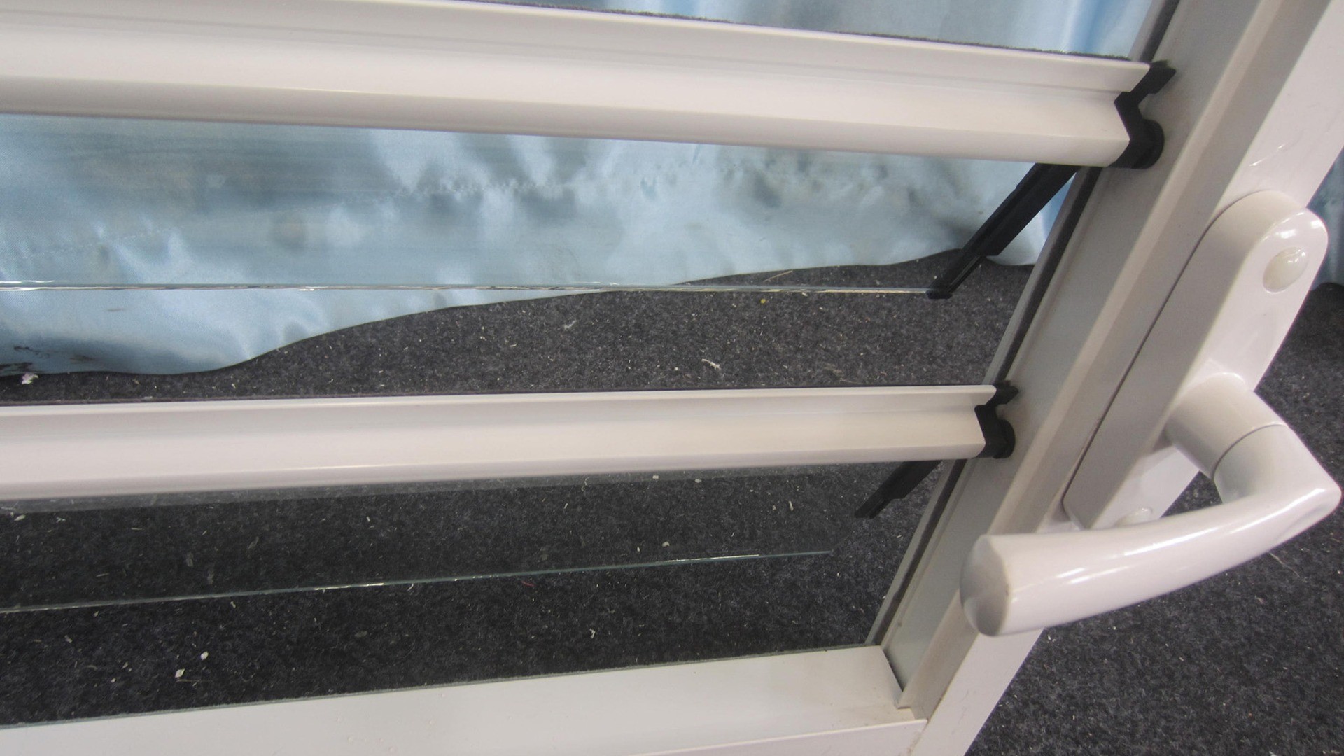 Blade ends seated in their shoes with the linkage arm behind: the carrier sets the pitch and carries the wind load, which is why blade thickness alone does not decide performance.