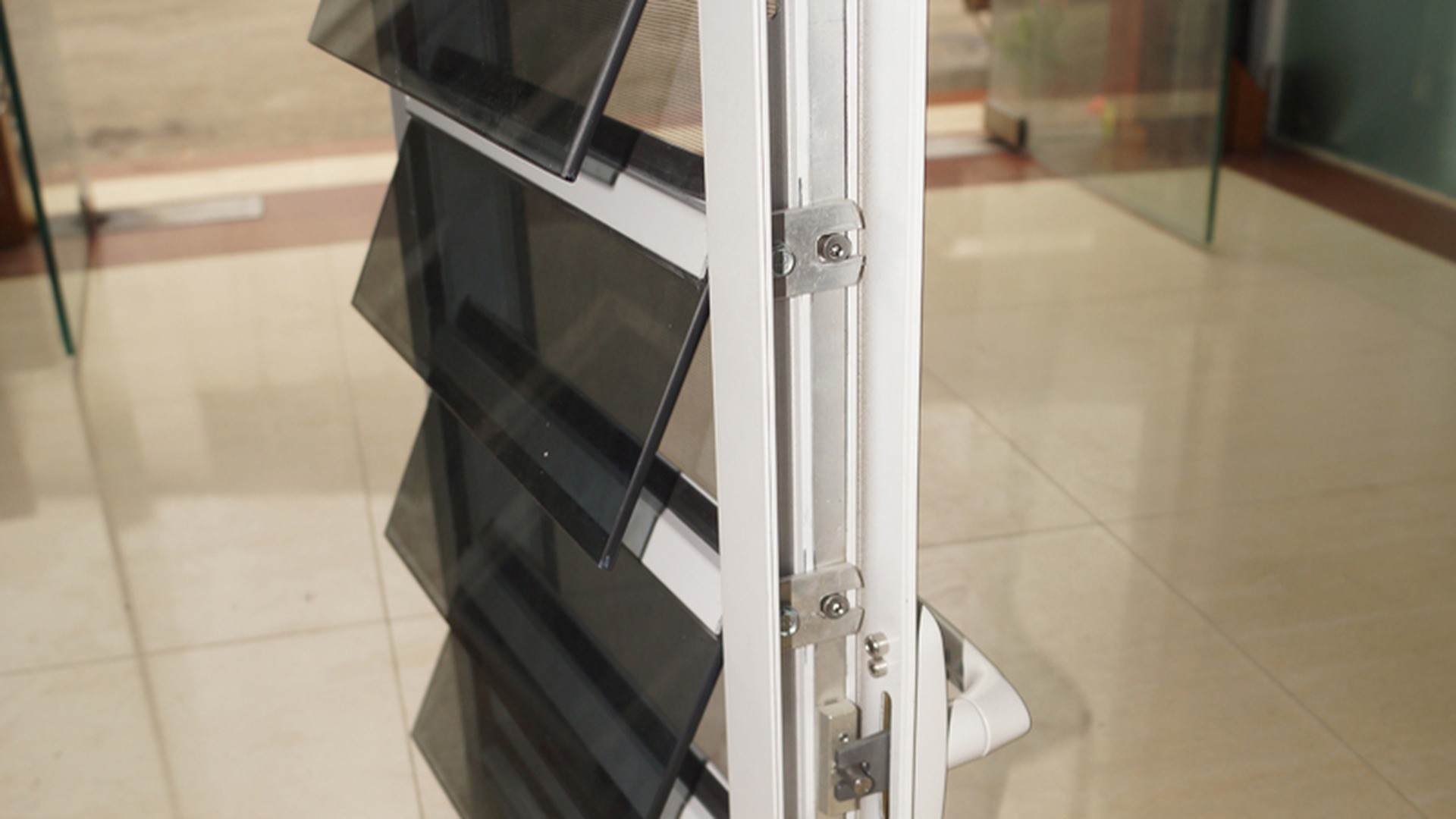Blade ends seated in their carriers on a completed unit: the shoe sets the pitch and carries each blade, which is why two louvers with the same glass can behave differently in wind and rain.