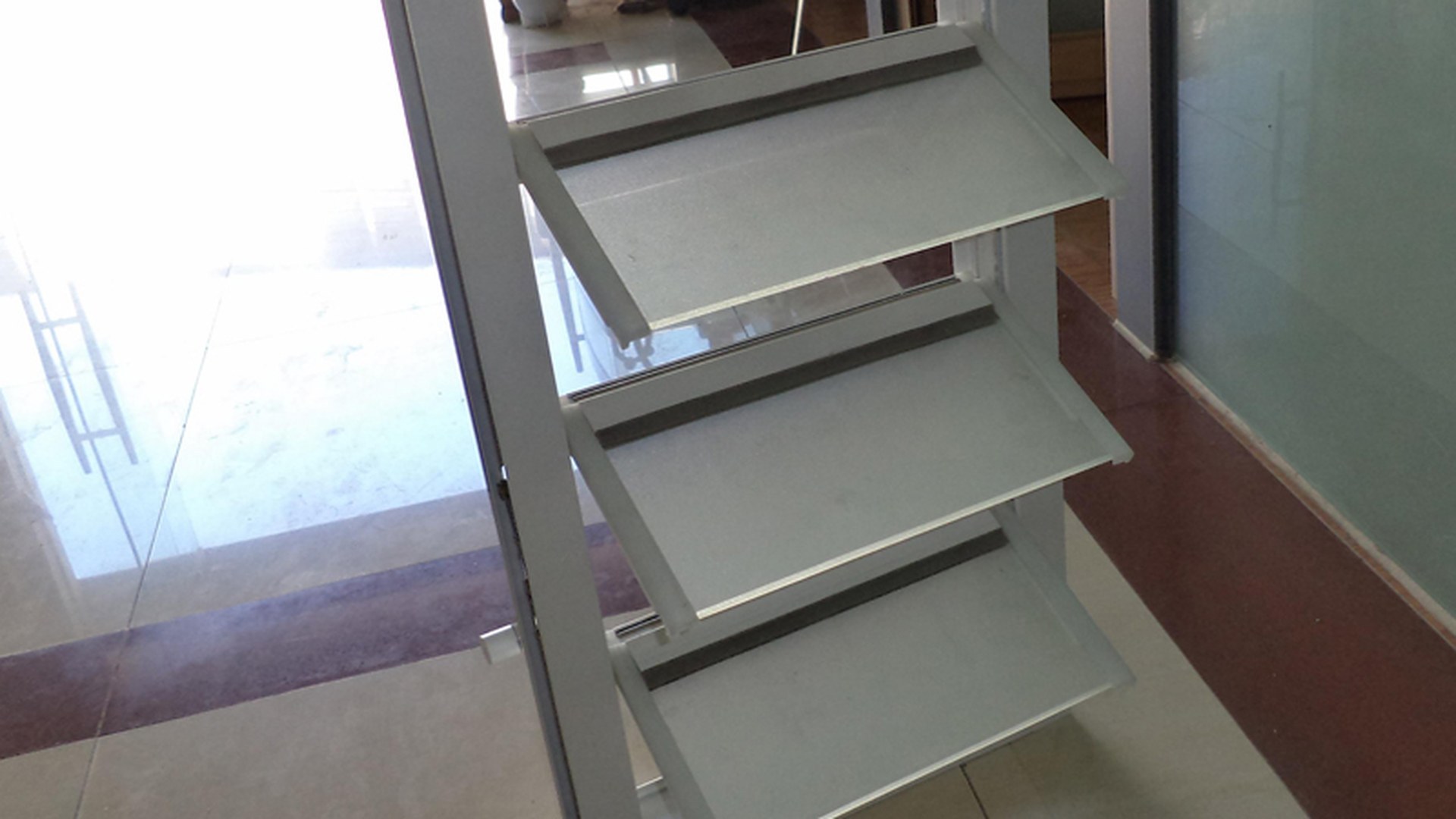 Blade ends and the side linkage in close-up, blades tilted open: each blade is carried by its own clip on a common linkage, which is why one handle moves the whole gallery.