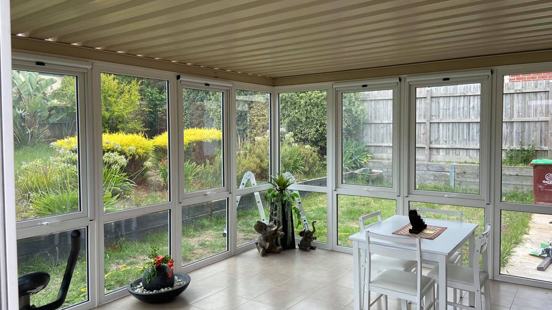 A conservatory glazed on three sides with uPVC frames: a room like this collects heat and glare all day, which is exactly the case an integral blind is bought for.