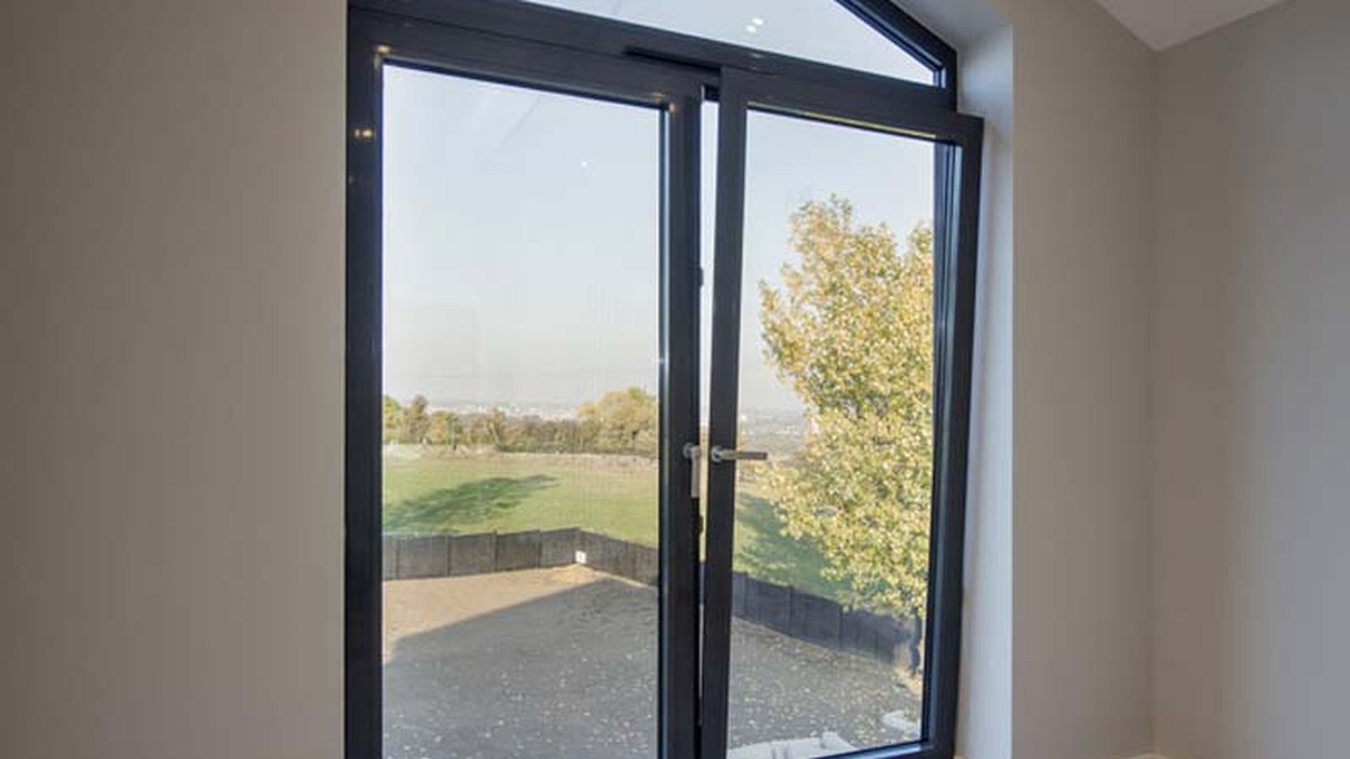 A glazed door pair set in a deep reveal: glass area, frame depth and the reveal detail are the three lines that move a door quote most.
