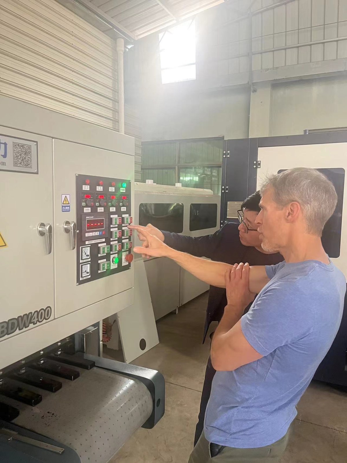 A factory engineer demonstrating machine settings
