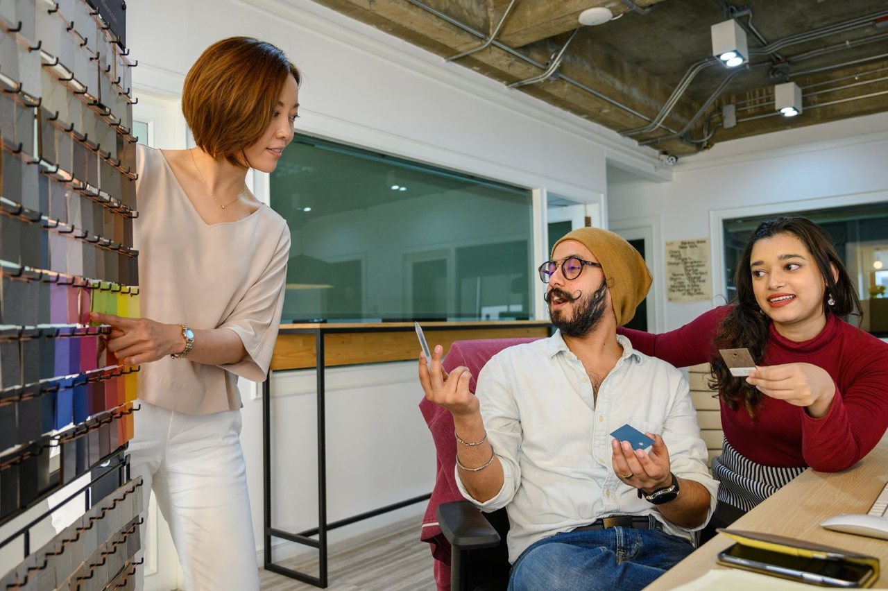 A sourcing team reviewing product material and colour samples in an office, representing product and packaging evaluation.