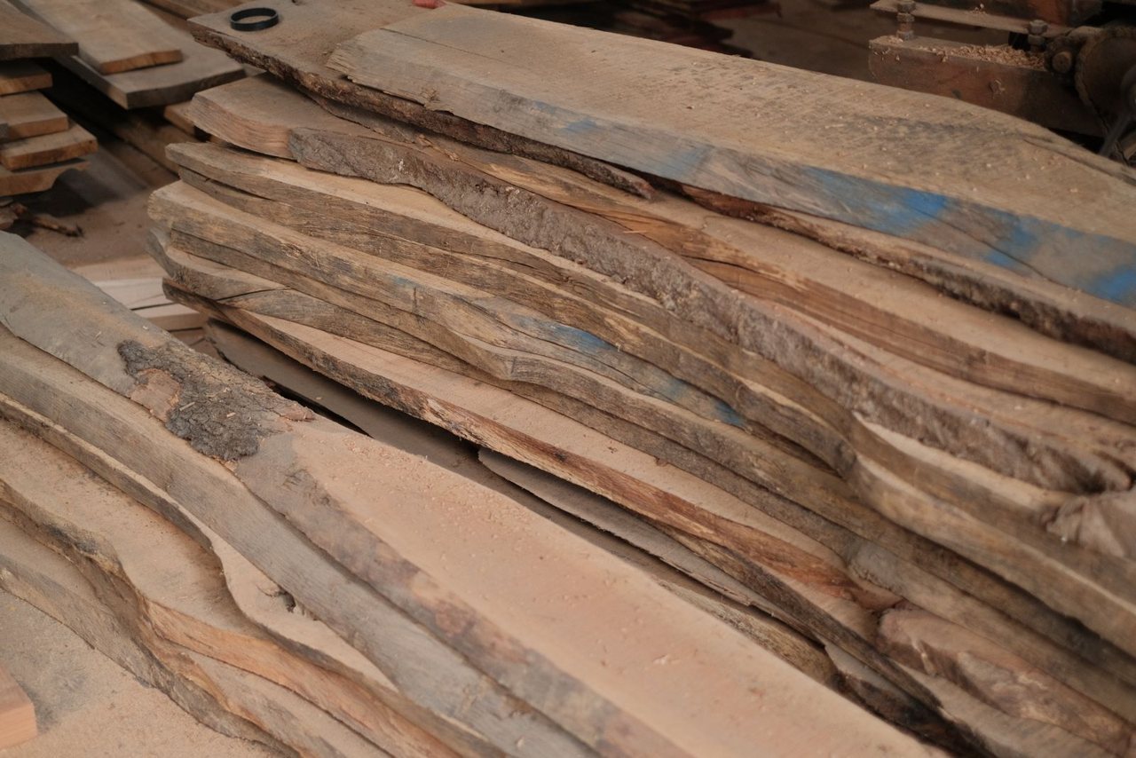 Stacked timber planks in a workshop, a wood commodity subject to EUDR due diligence.